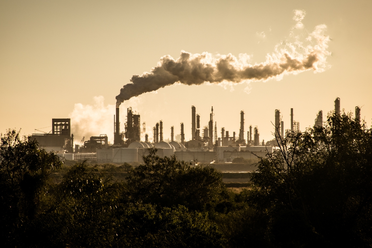 a large industrial complex releasing smoke and chemicals into the atmosphere